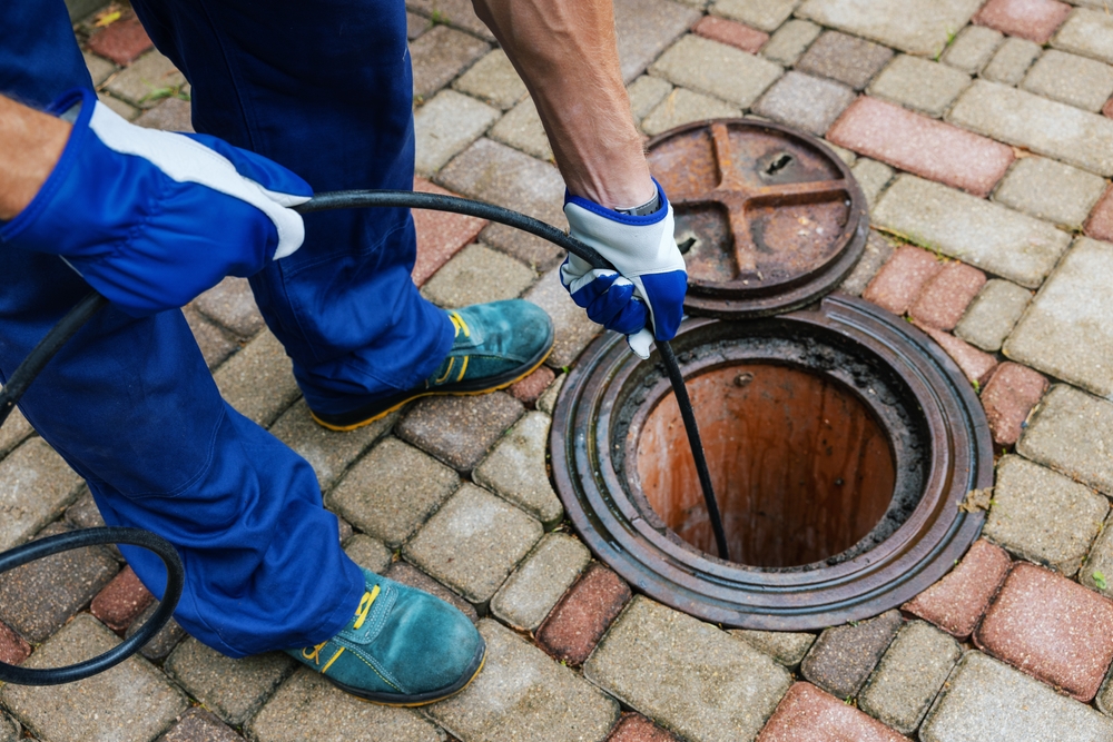 Plumber cleaning a clogged drainage with hydro jetting